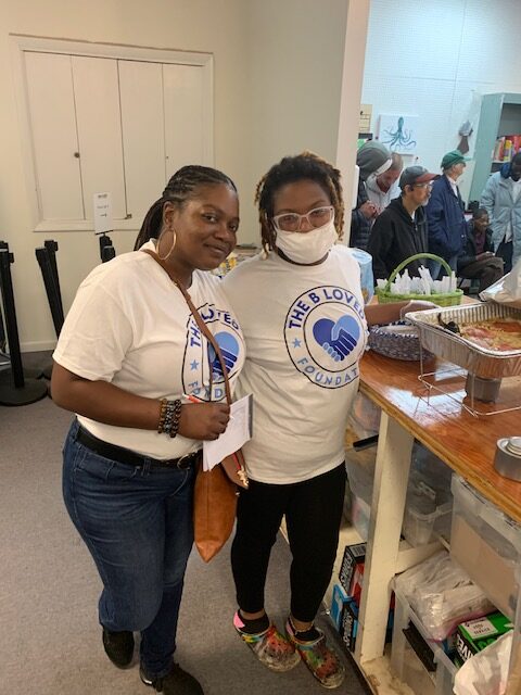 Two volunteers smiling during the feeding the homeless event.