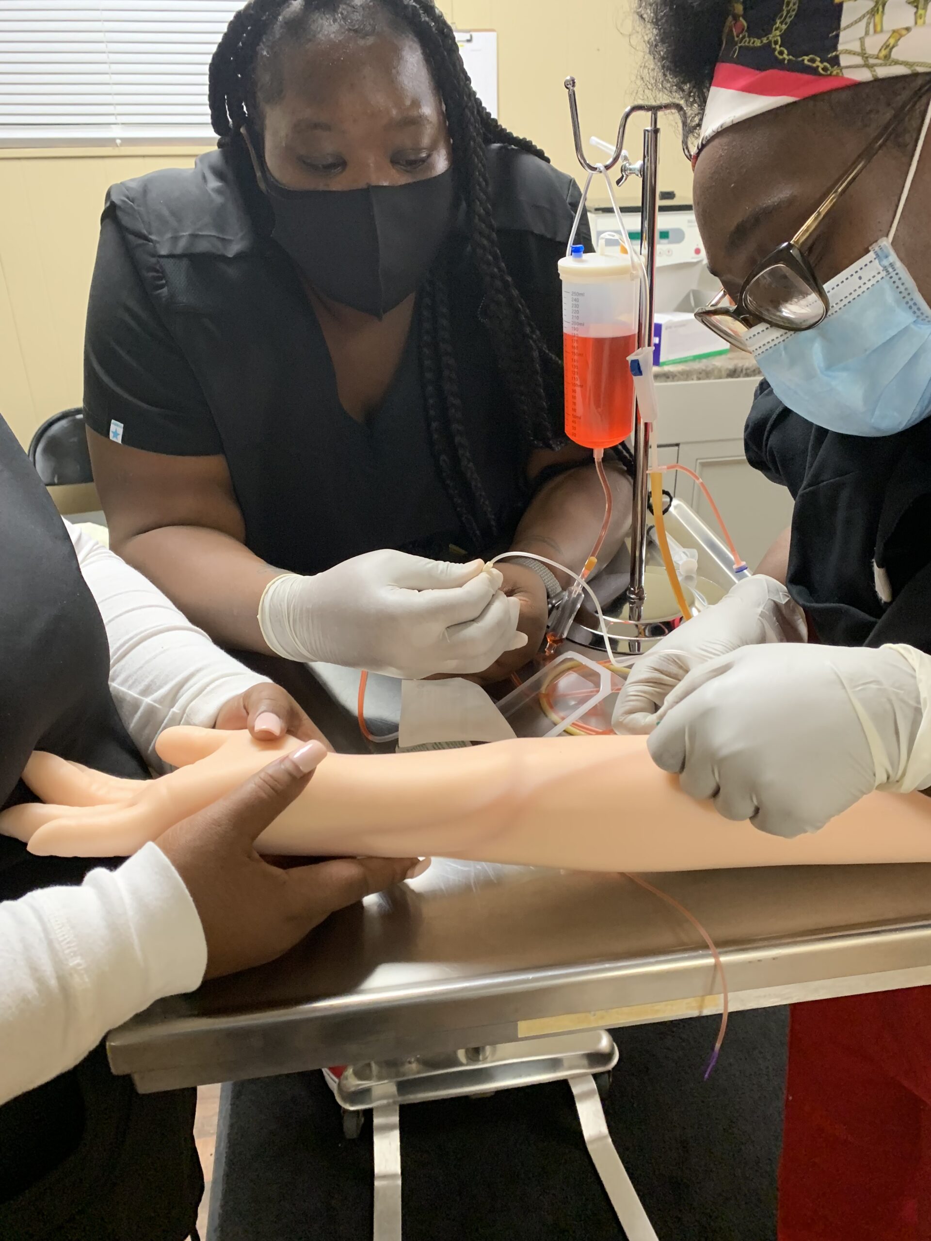 A picture of a woman practicing giving an IV.