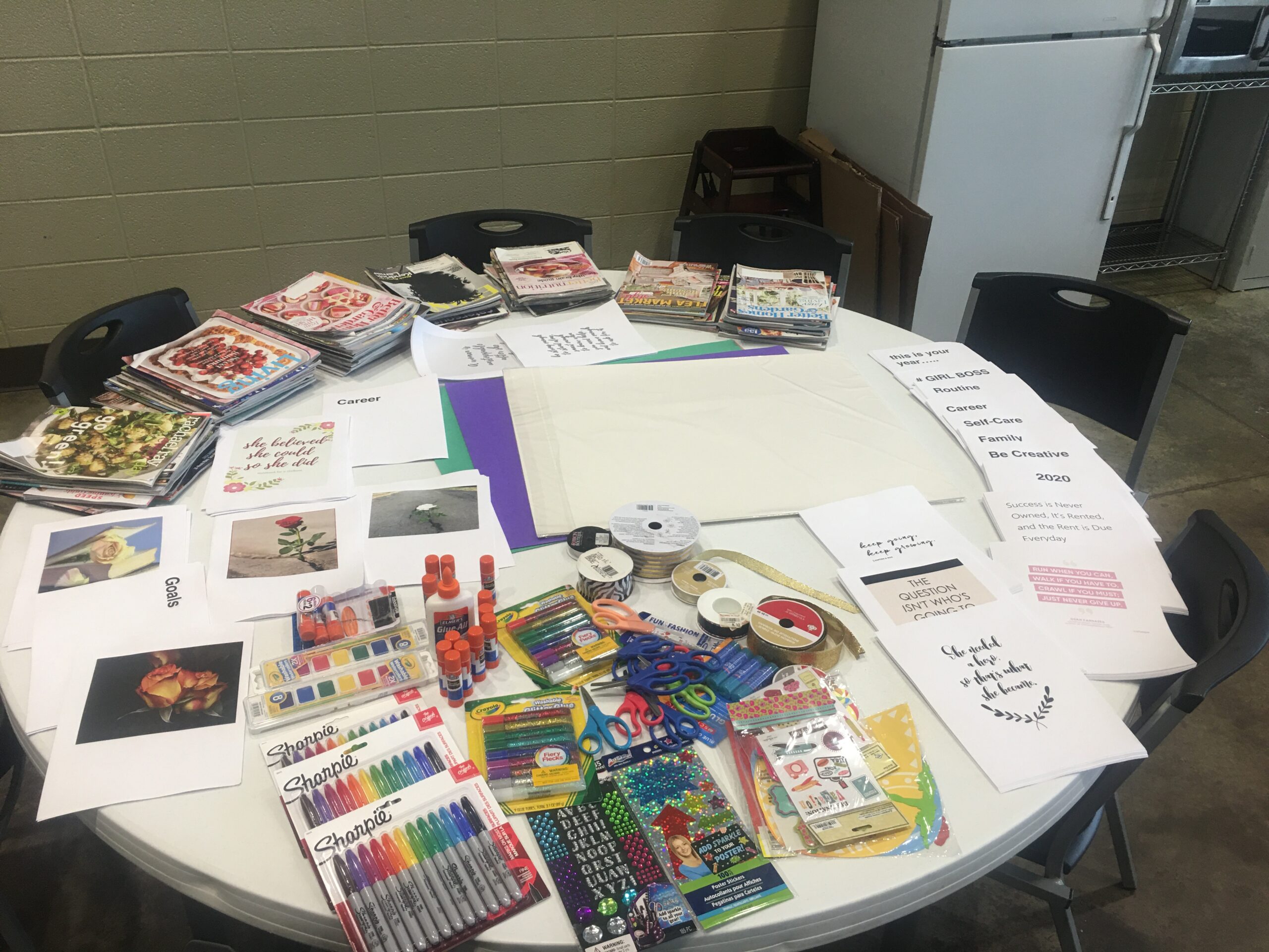 A picture of a table with a variety of arts and crafts supplies to make vision boards.